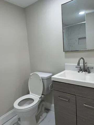 a bathroom with a toilet sink and mirror