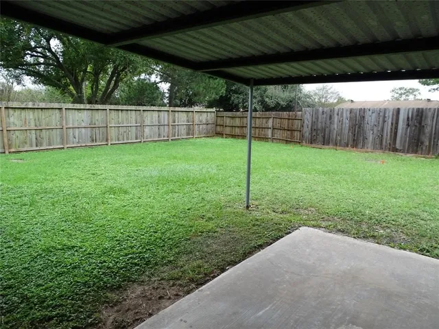 a view of a backyard with grass and entertaining space