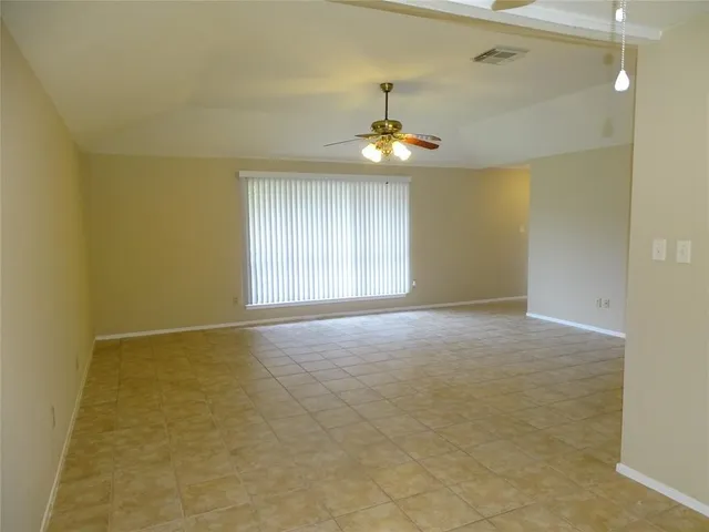 en empty room with windows and ceiling fan