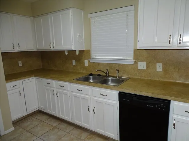 a kitchen with granite countertop white cabinets and sink