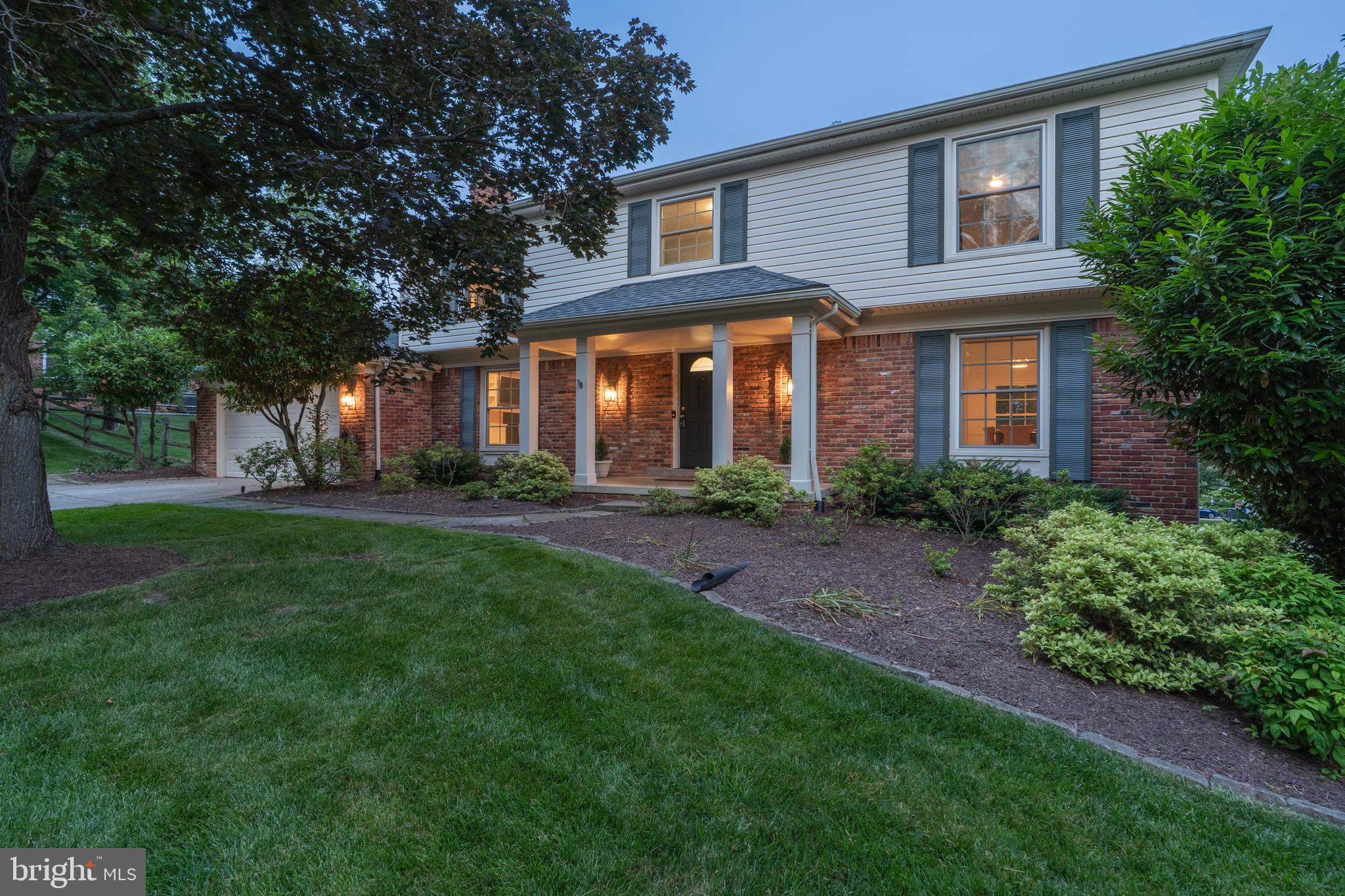 a front view of a house with a yard and trees