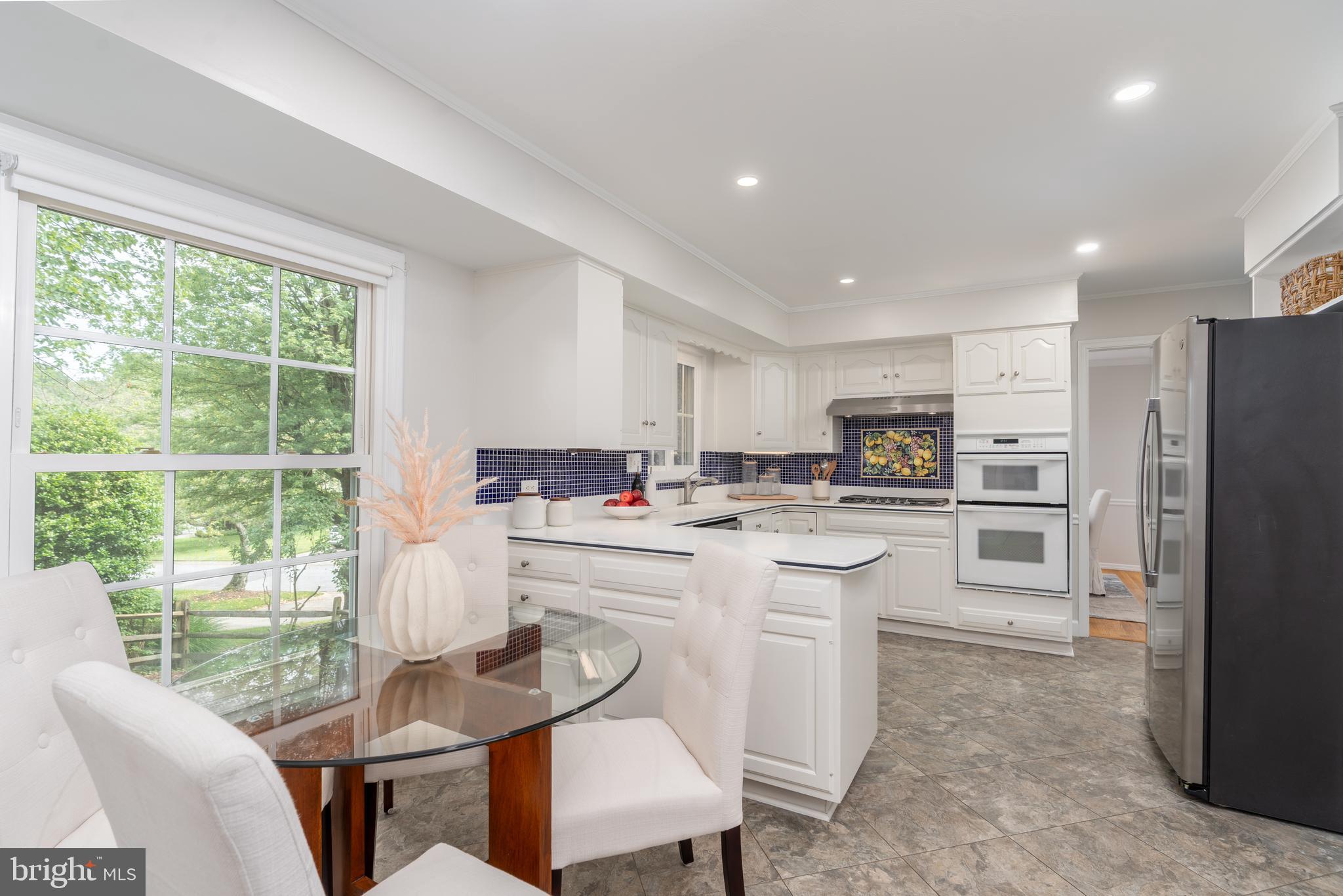 8712 Fox Run Potomac, MD 20854 - Photo 19 of 49 a kitchen with refrigerator cabinets dining table and chairs