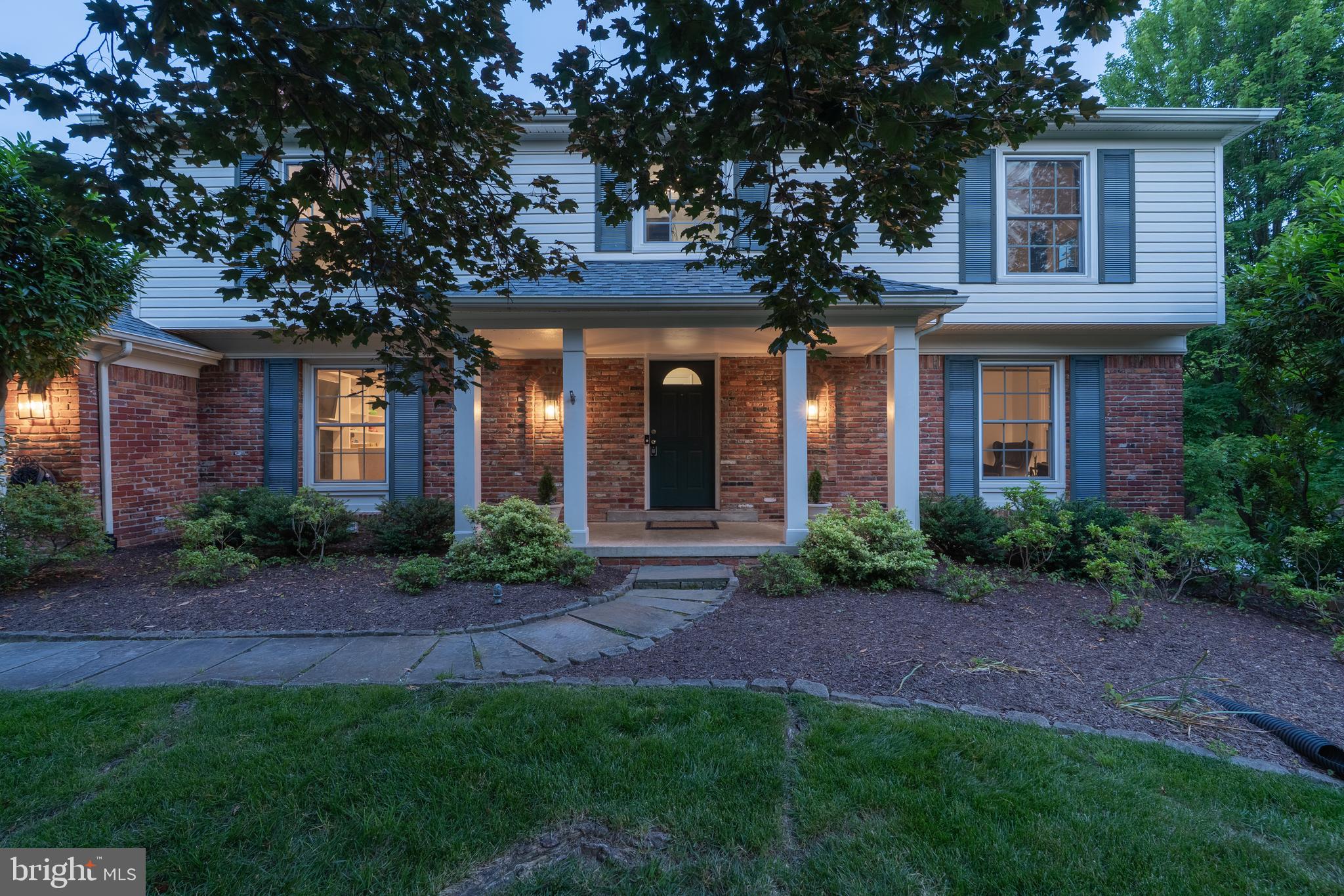 8712 Fox Run Potomac, MD 20854 - Photo 2 of 49 a view of a brick house with a yard and plants