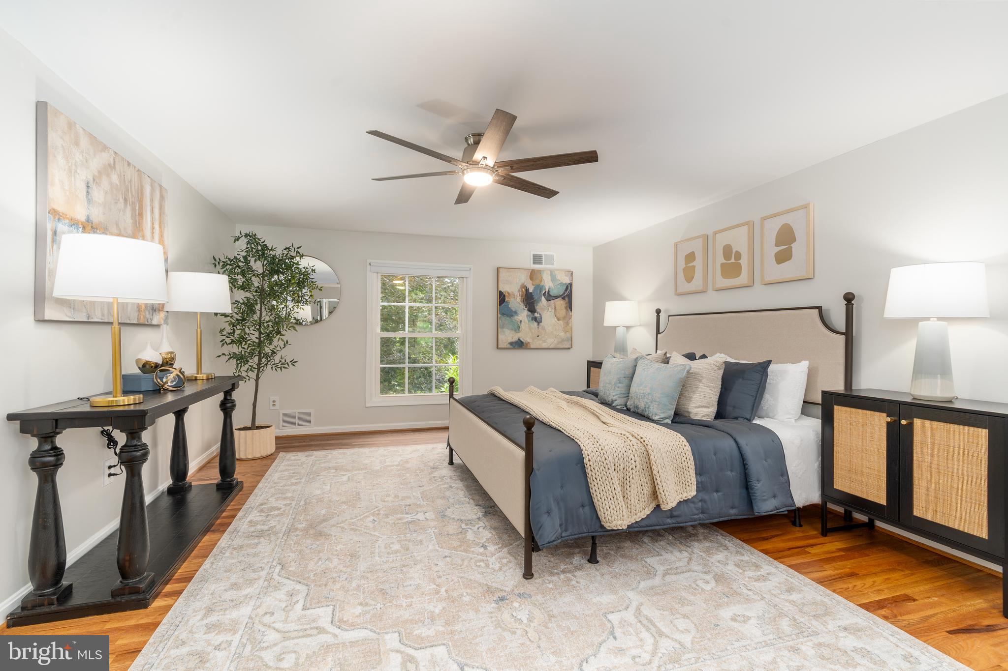 8712 Fox Run Potomac, MD 20854 - Photo 23 of 49 a spacious bedroom with a bed and a chandelier