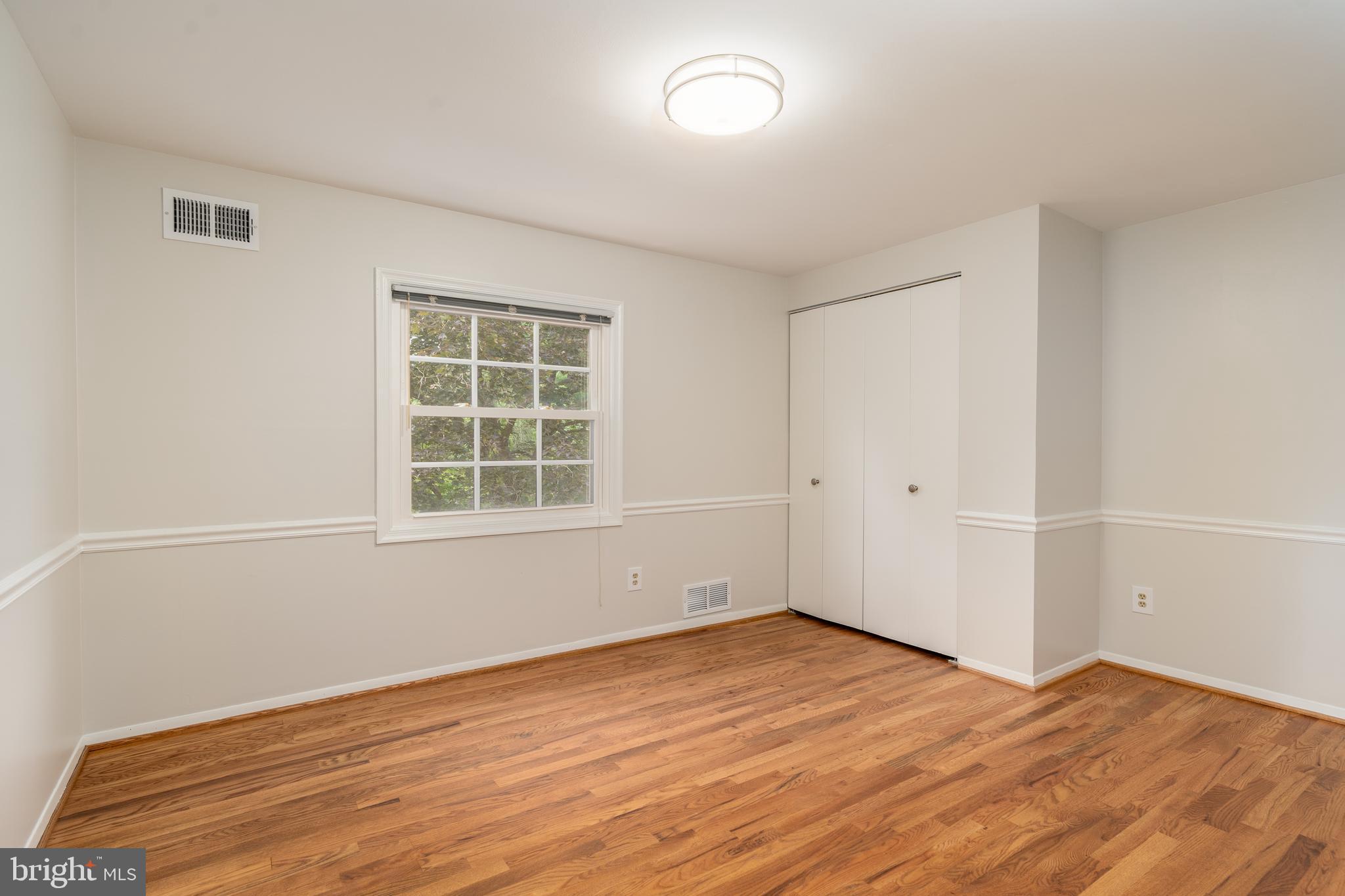 8712 Fox Run Potomac, MD 20854 - Photo 30 of 49 an empty room with wooden floor and windows