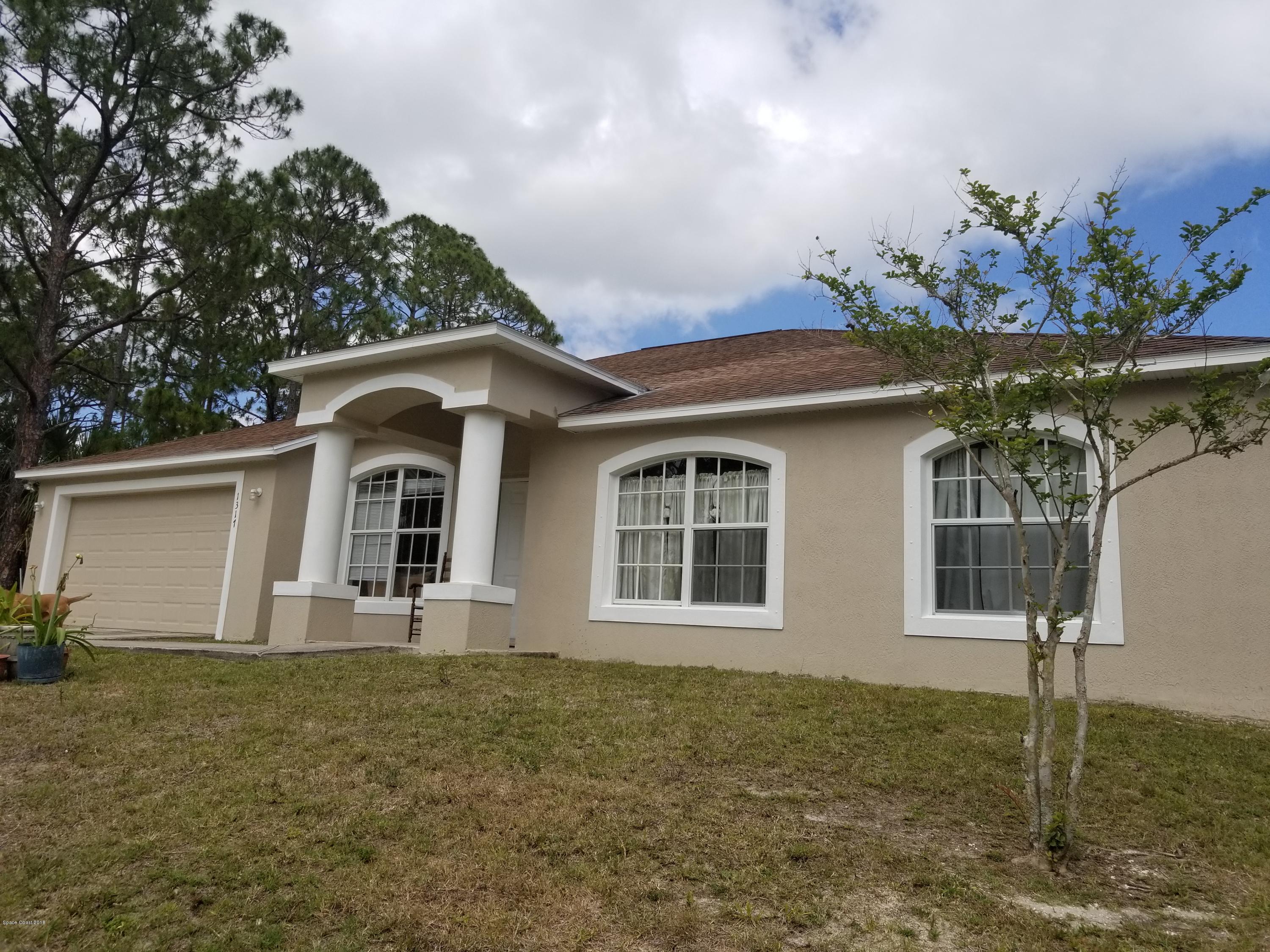 1317 Degroodt Road Southwest Palm Bay, FL 32908 - Photo 1 of 26 a front view of a house with garden