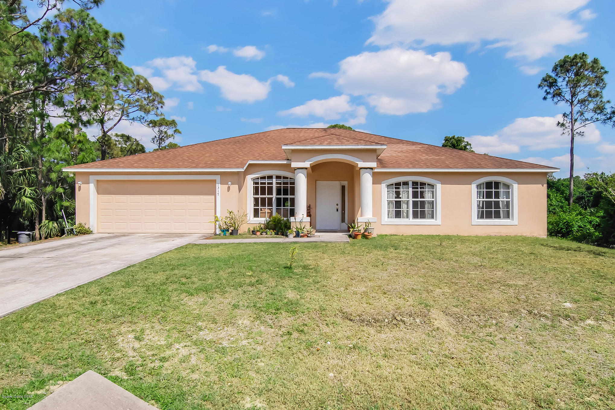 1317 Degroodt Road Southwest Palm Bay, FL 32908 - Photo 2 of 26 a front view of a house with a garden