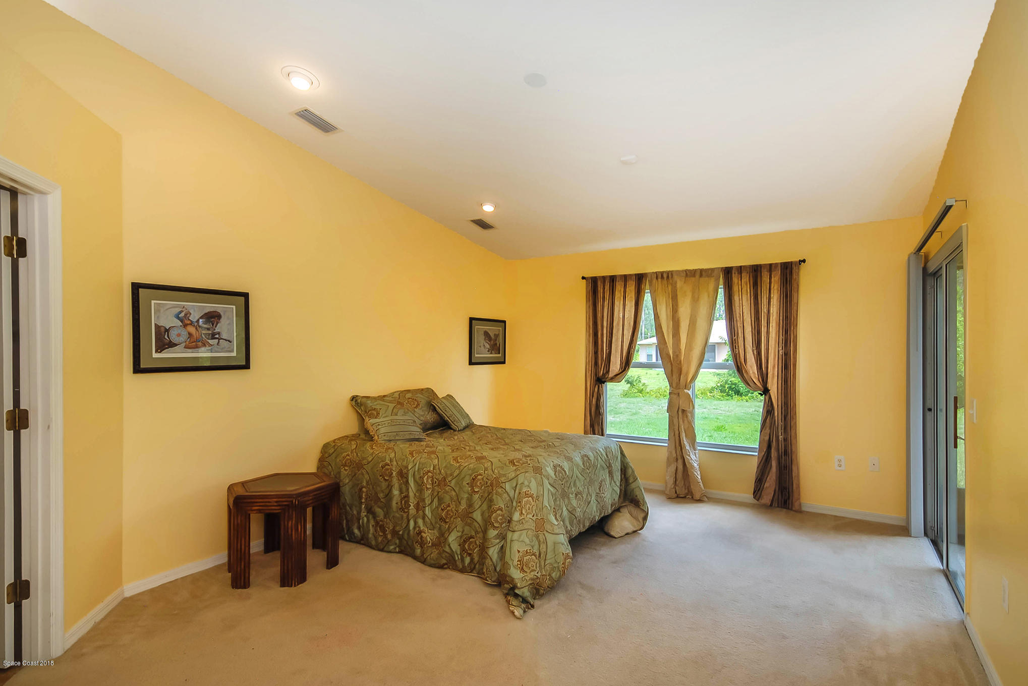 1317 Degroodt Road Southwest Palm Bay, FL 32908 - Photo 14 of 26 a bedroom with a bed and a dresser next to a window