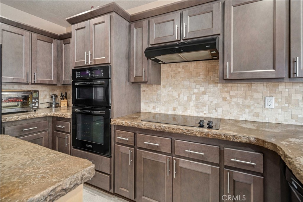 9251 Elizabeth Lake Road Leona Valley, CA 93551 - Photo 12 of 53 a kitchen with granite countertop a refrigerator stove and microwave