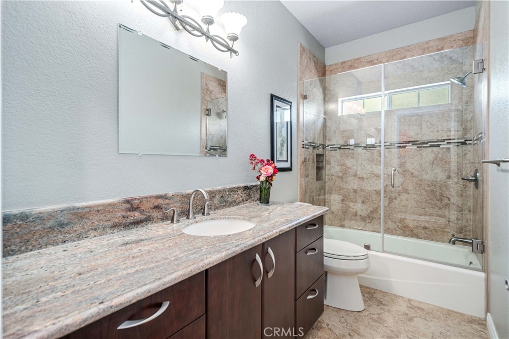 9251 Elizabeth Lake Road Leona Valley, CA 93551 - Photo 17 of 53 a bathroom with a granite countertop sink a toilet and shower