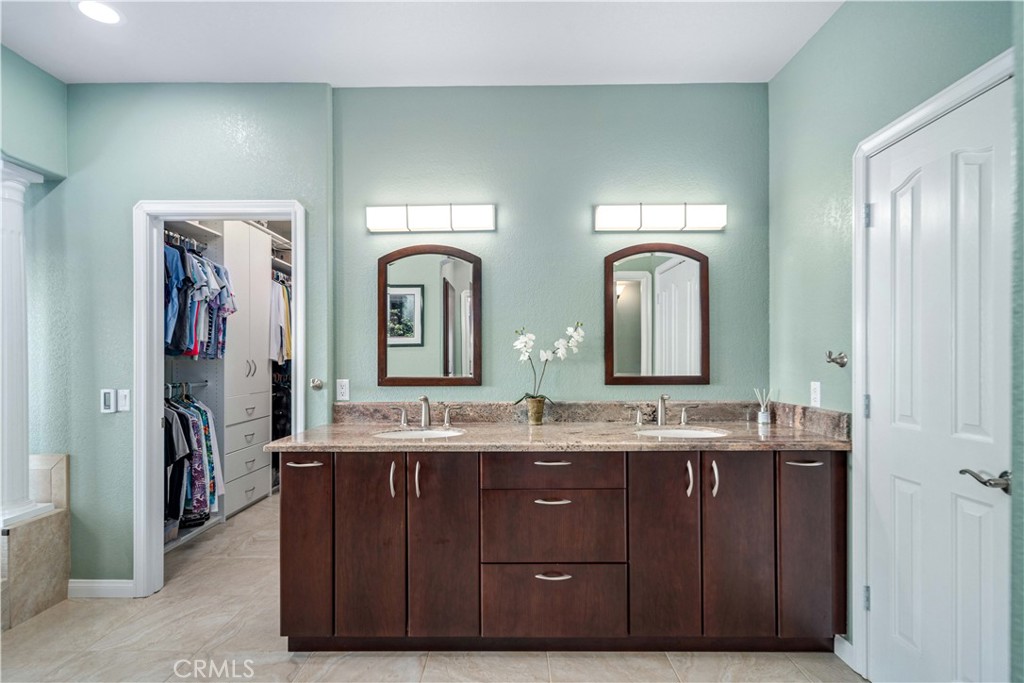 9251 Elizabeth Lake Road Leona Valley, CA 93551 - Photo 23 of 53 a bathroom with a granite countertop sink a large mirror and a shower