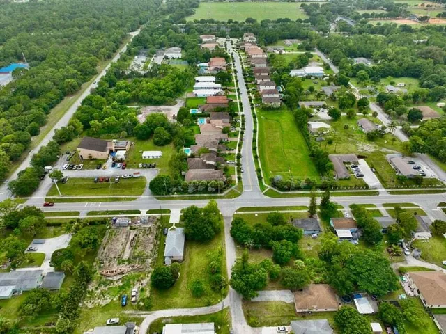an aerial view of residential houses with outdoor space and street view