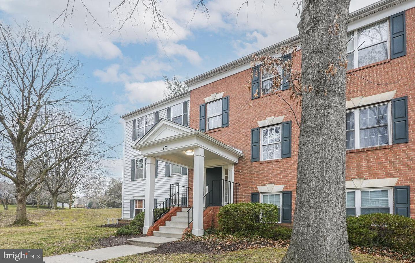 12 Normandy Square Court, Unit 3AE Silver Spring, MD 20906 - Photo 1 of 12 a view of a brick house next to a yard with large trees