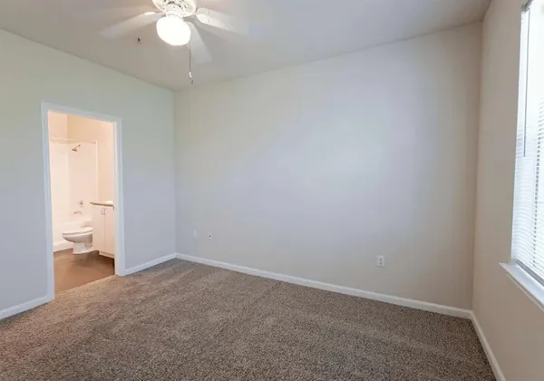 an empty room with chandelier fan