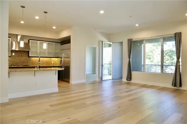 a view of a kitchen with kitchen island a counter top space stainless steel appliances and a window
