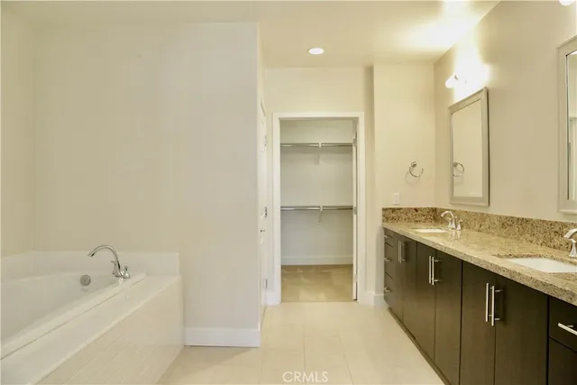 a bathroom with a tub sink and mirror