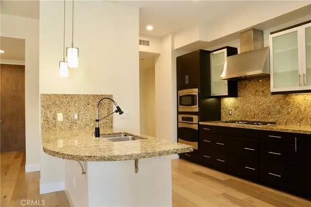 a kitchen with stainless steel appliances granite countertop a sink and a refrigerator
