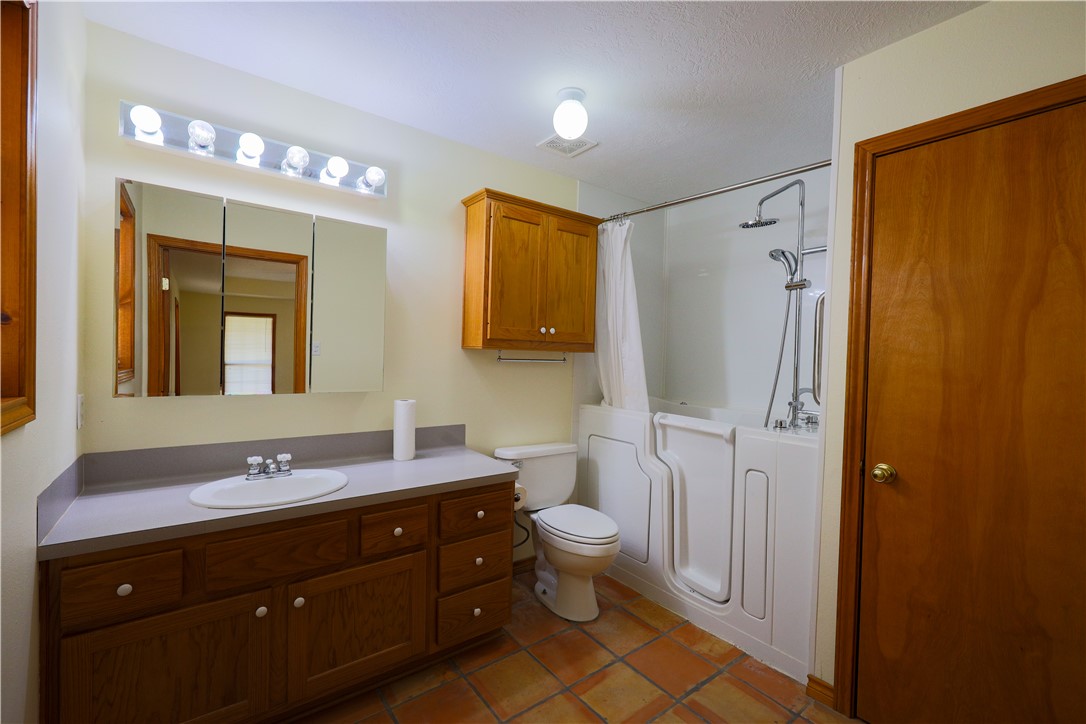 16403-16515 Macey Road Hearne, TX 77859 - Photo 28 of 46 a bathroom with a double vanity sink toilet mirror and shower