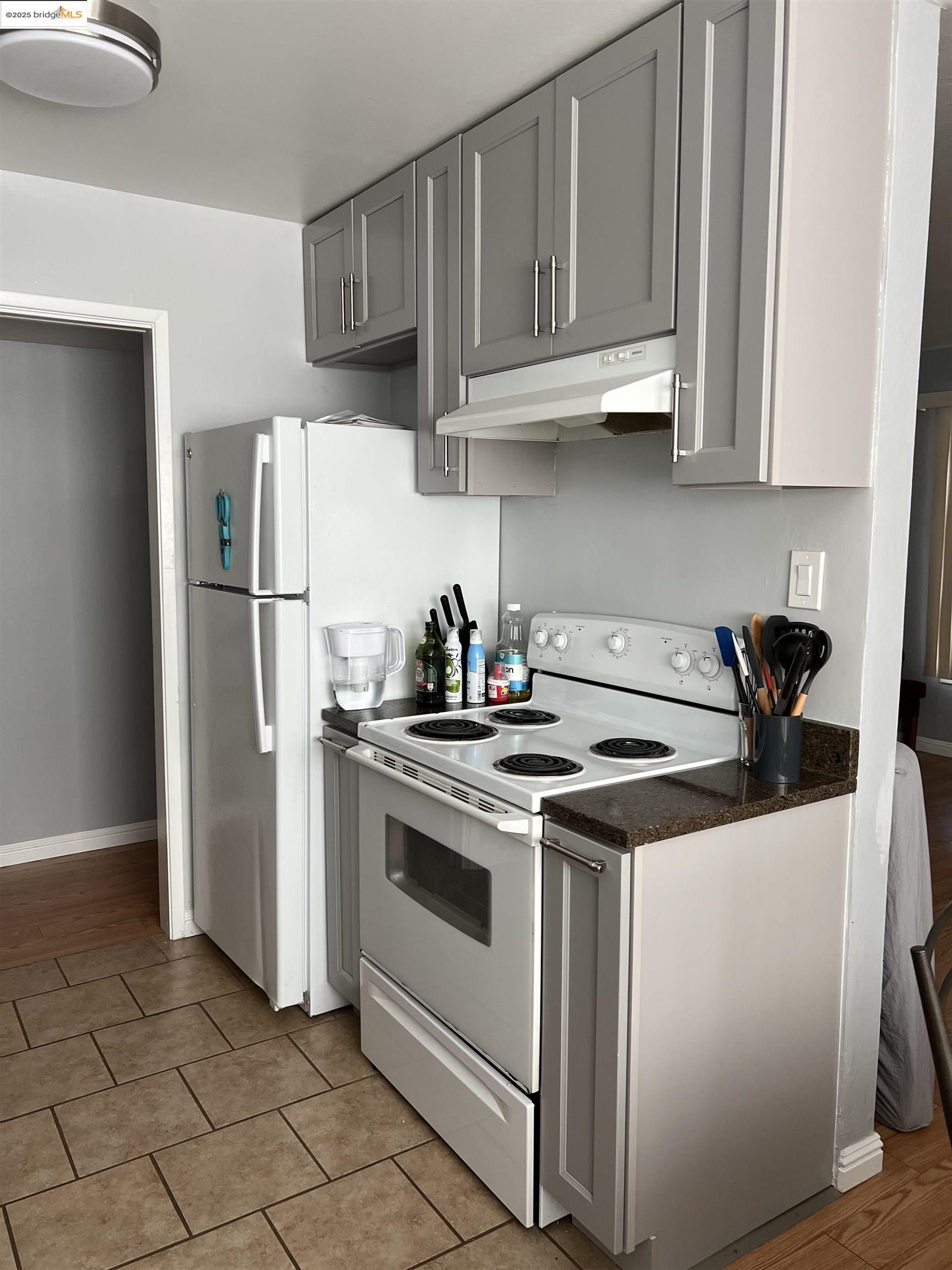 2636 Warring Street, Unit 104 Berkeley, CA 94704 - Photo 7 of 8 a kitchen with stainless steel appliances granite countertop a refrigerator a stove a sink and dishwasher