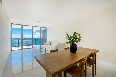 a view of a dining room with furniture a potted plant and wooden floor