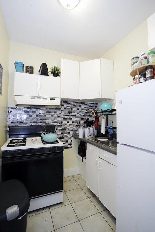 934 Middle Street Fall River, MA 02721 - Photo 15 of 30 a kitchen with stainless steel appliances granite countertop a sink stove and refrigerator