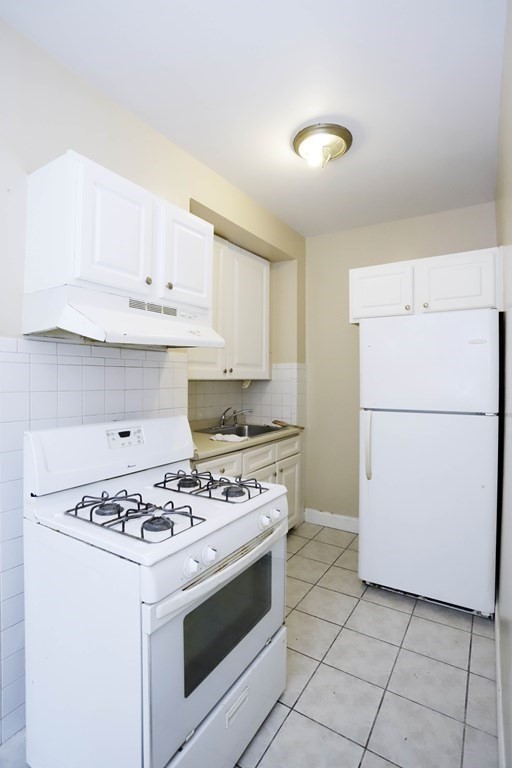 934 Middle Street Fall River, MA 02721 - Photo 6 of 30 a white kitchen with a stove and a refrigerator