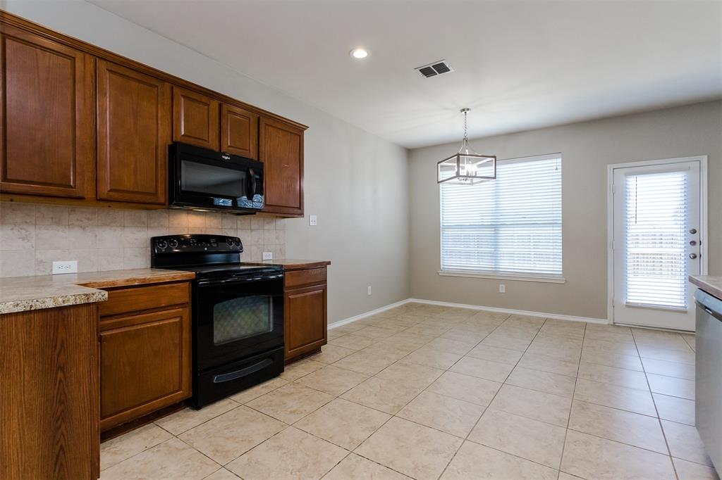203 Arabian Road Waxahachie, TX 75165 - Photo 5 of 24 Kitchen featuring wood cabinetry, a built-in microwave, and a black electric range