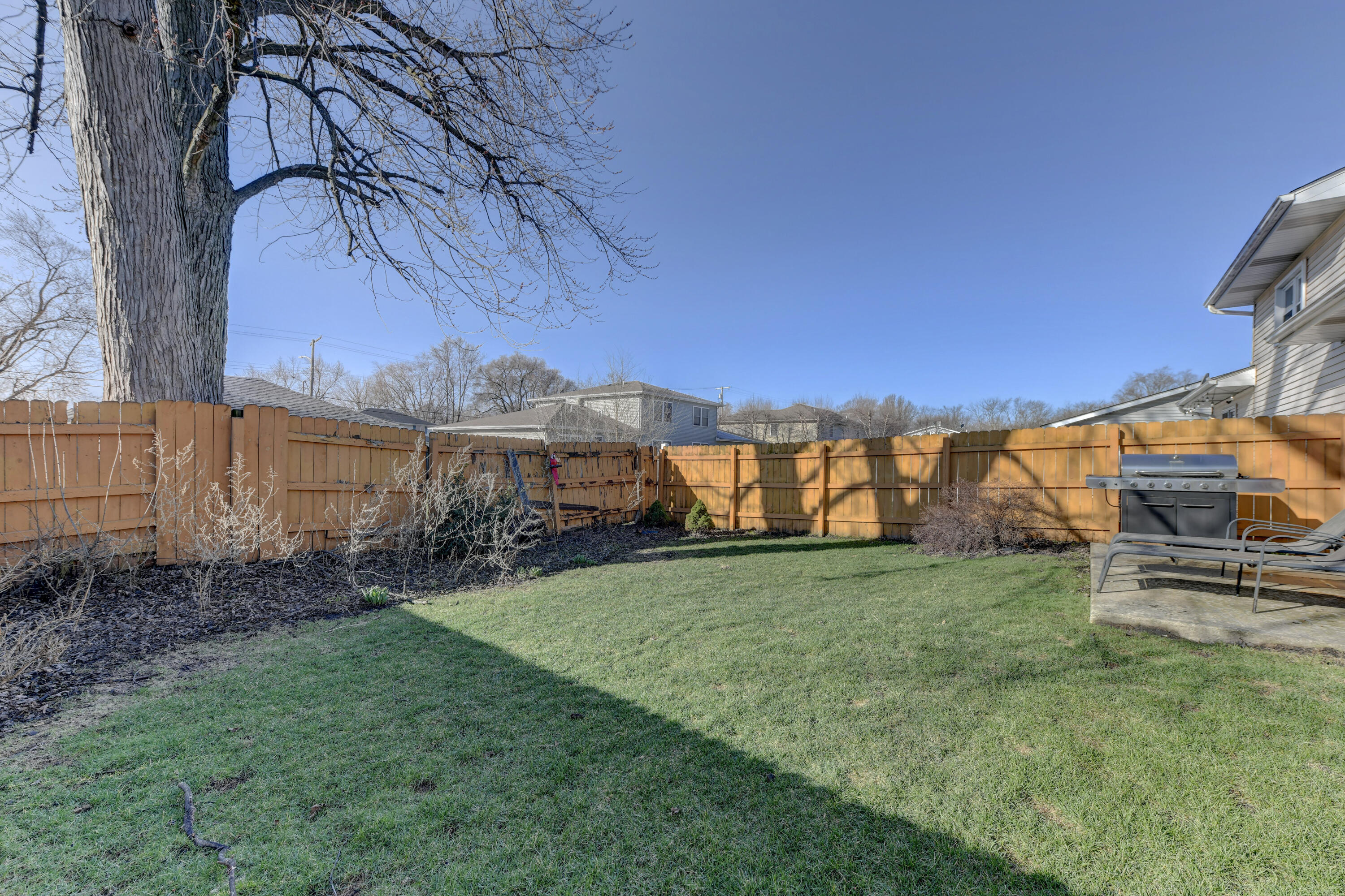 2626 41st Place Highland, IN 46322 - Photo 12 of 24 a view of a backyard with plants and a large tree