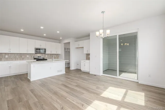 a kitchen with stainless steel appliances granite countertop a refrigerator and a sink
