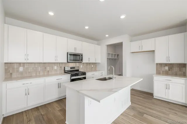 a kitchen with sink a microwave and cabinets