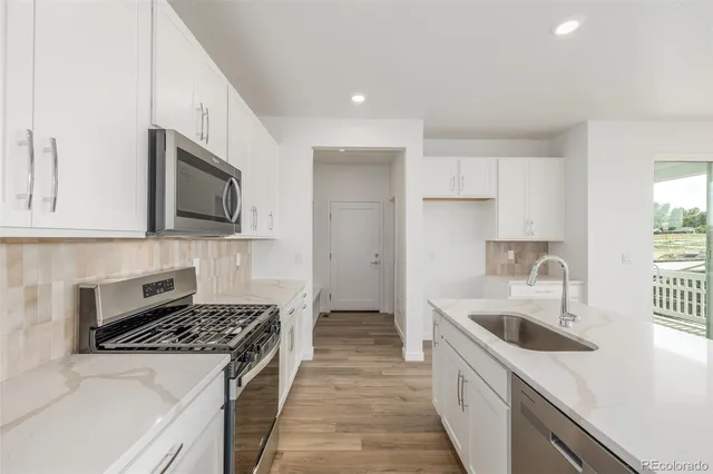 a kitchen with a sink stove top oven and cabinets