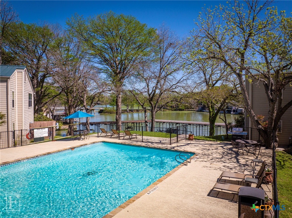 a row of palm trees sitting in a yard with swimming pool