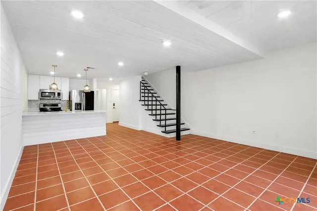 a view of an empty room with a kitchen