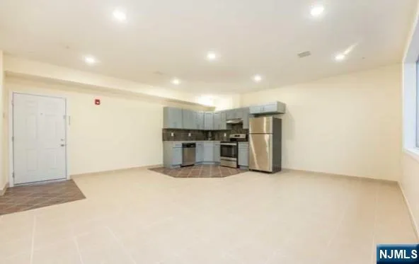 a view of kitchen with refrigerator and chairs