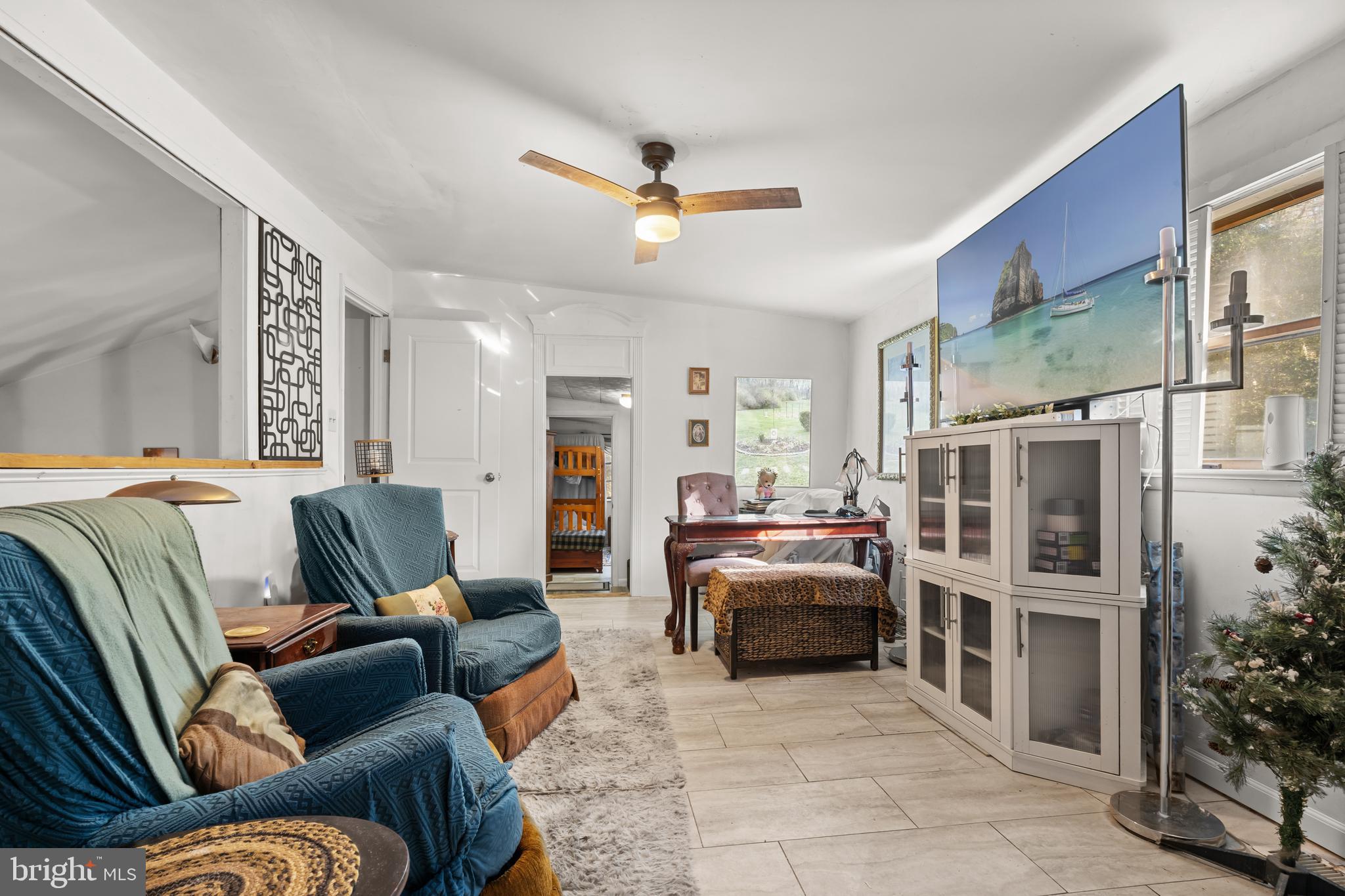 13640 Collins Pond Road East Georgetown, DE 19947 - Photo 28 of 41 a living room with furniture ceiling fan and a rug