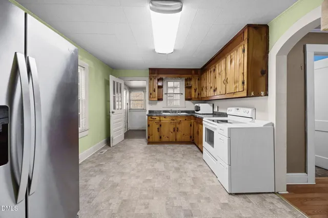 a kitchen that has a sink a refrigerator and a stove