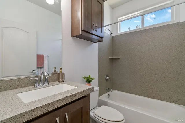 a bathroom with a granite countertop sink toilet and bathtub