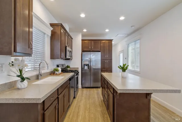 a kitchen with stainless steel appliances granite countertop sink stove top oven and refrigerator