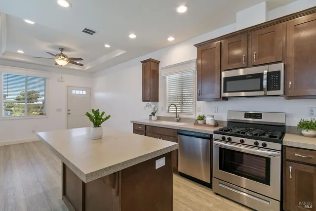 a kitchen with stainless steel appliances a stove microwave and sink