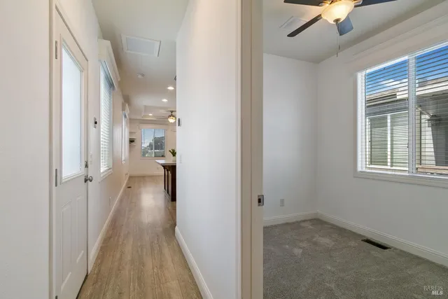 a view of a hallway with a window and wooden floor