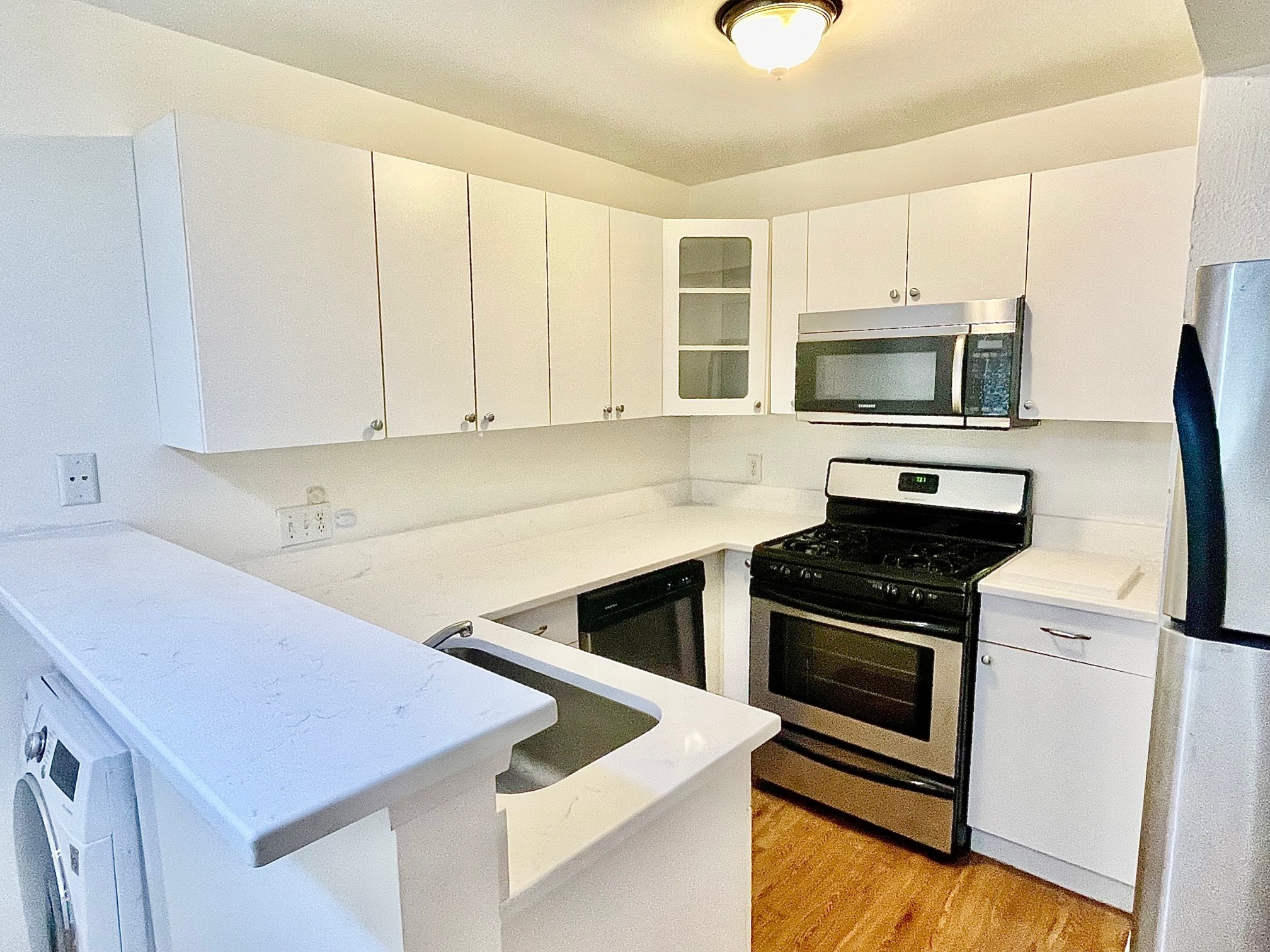 a kitchen with stainless steel appliances white cabinets and a stove top oven