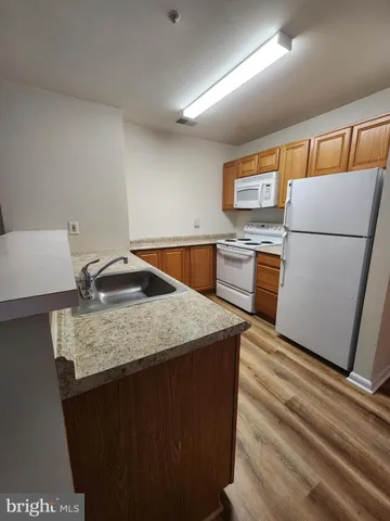 a kitchen with microwave a refrigerator and a sink