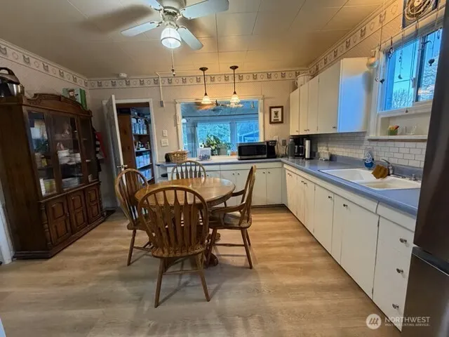 a kitchen with a table chairs microwave and cabinets
