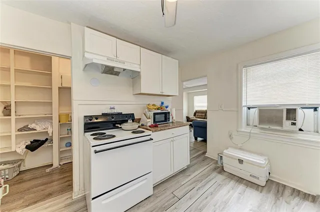 a kitchen with white cabinets and appliances