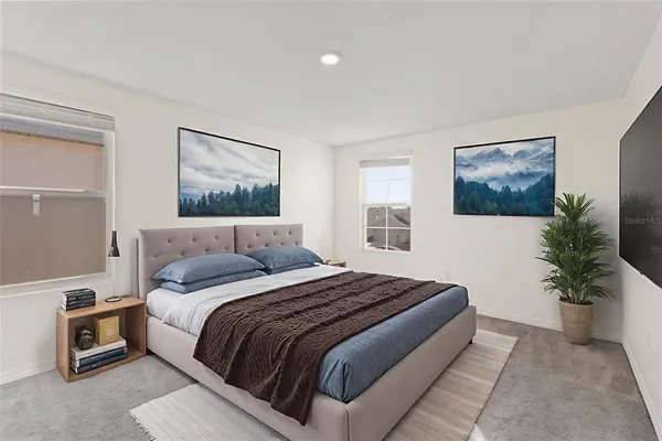 a bedroom with a large bed and a potted plant
