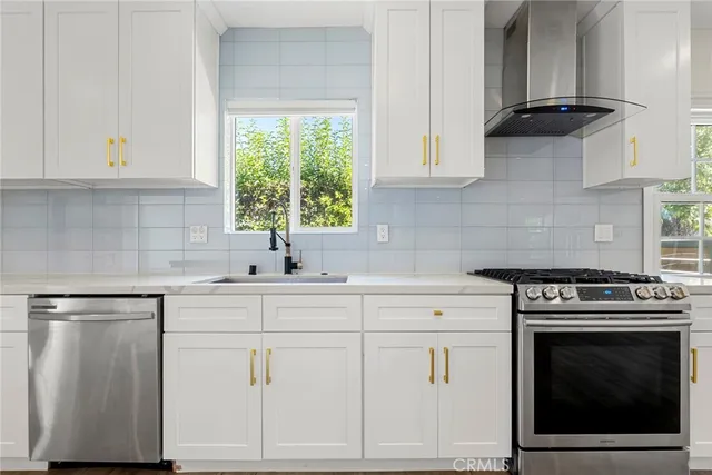 a kitchen with white cabinets and appliances