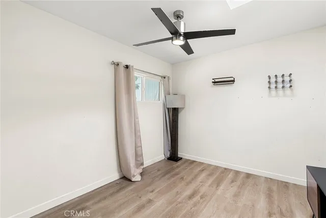 a view of a livingroom with wooden floor and a ceiling fan