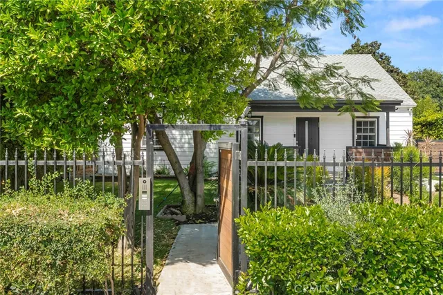 a view of house with a yard and plants