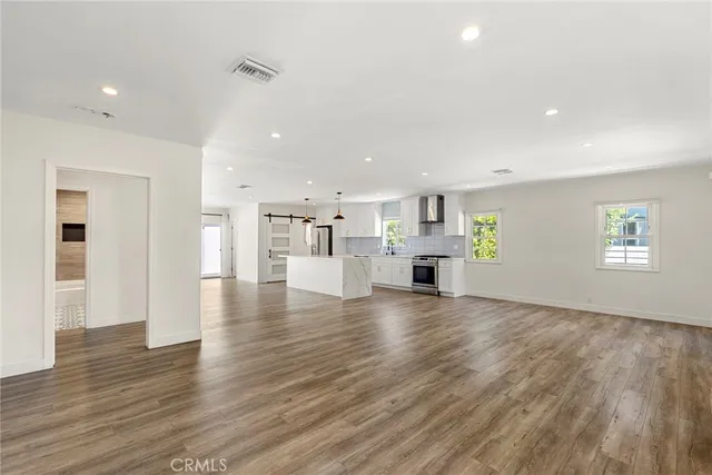 a view of empty room with kitchen and window