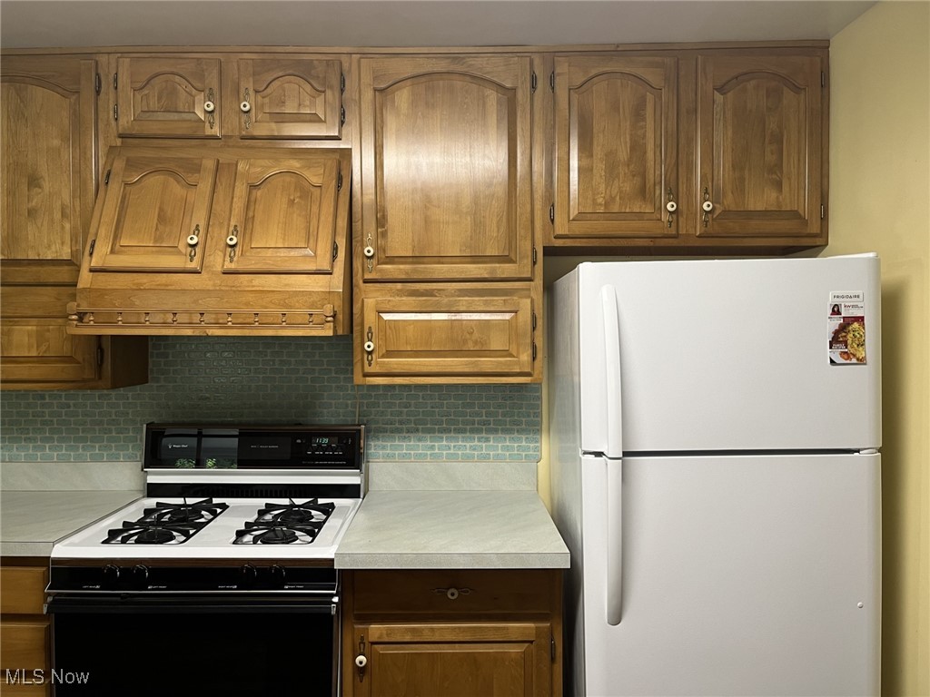 6735 Hathaway Road Cleveland, OH 44125 - Photo 8 of 44 Kitchen featuring custom range hood, white appliances, and backsplash